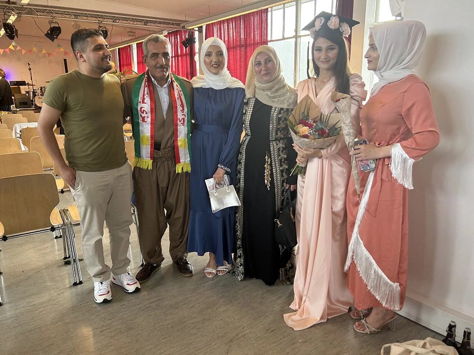 Ein Bild der Familie bei der Zeugnisverleihung in feierlichen, traditionellen Gew&auml;ndern.